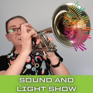 Jenny Lynch blowing into a trumpet. Coloured lines are bursting out of the trumpet.